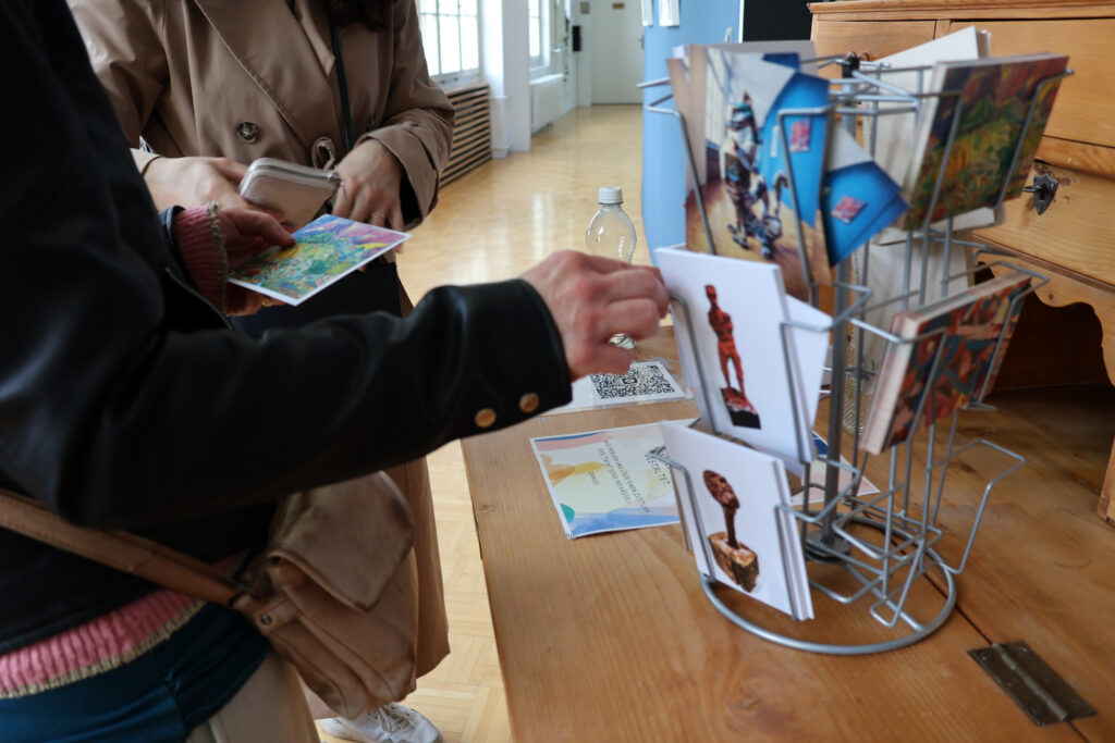 Gefüllter Postkartenständer mit gestalteten Karten aus dem Tageszentrum.